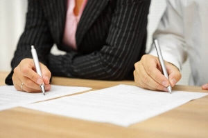 divorcing couple signing paperwork together